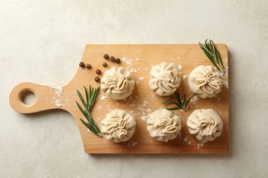 Beyaz desenli arka planda khinkali, baharat ve un olan tahta