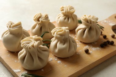 Beyaz desenli arka planda khinkali, baharat ve un olan tahta