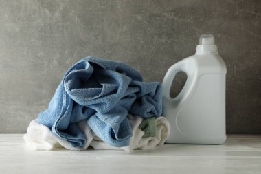 Deterjan ve buruşuk havlular gri arka plana karşı