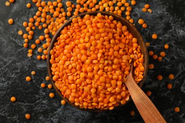 Siyah dumanlı masada kırmızı baklava desenli kase ve kaşık.