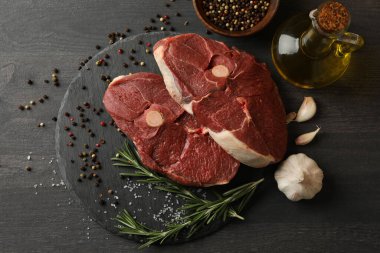 Biftek tepsisi, otlu ve ahşap arka planda baharatlı.