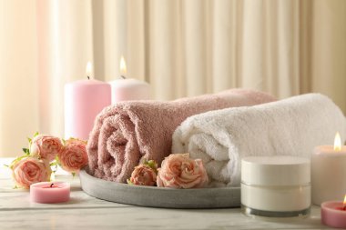 Beyaz ahşap masada kokulu mumlarla vücut bakımı kavramı