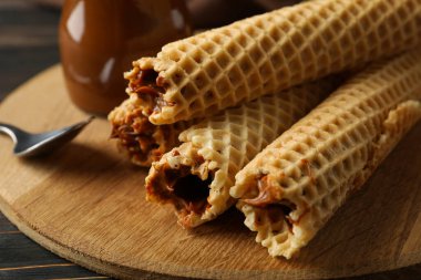 Tahta arka planda yoğunlaştırılmış sütle birlikte gofretli lezzetli yemek kavramı