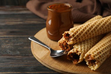 Tahta arka planda yoğunlaştırılmış sütle birlikte gofretli lezzetli yemek kavramı