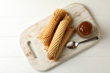 Tahta zemin üzerinde yoğunlaştırılmış süt olan gofret ruloları olan tahta.