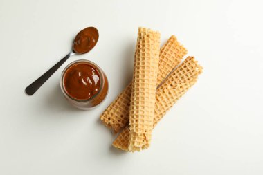 Beyaz arka planda yoğunlaştırılmış sütlü gofret ve kavanoz.