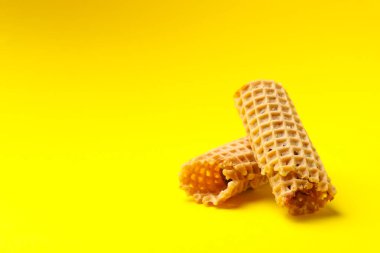 Sarı arka planda yoğunlaştırılmış sütle lezzetli gofretler.