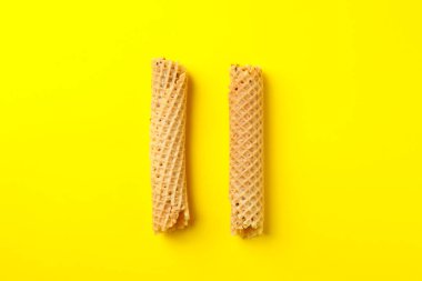 Sarı arka planda yoğunlaştırılmış sütle lezzetli gofretler.