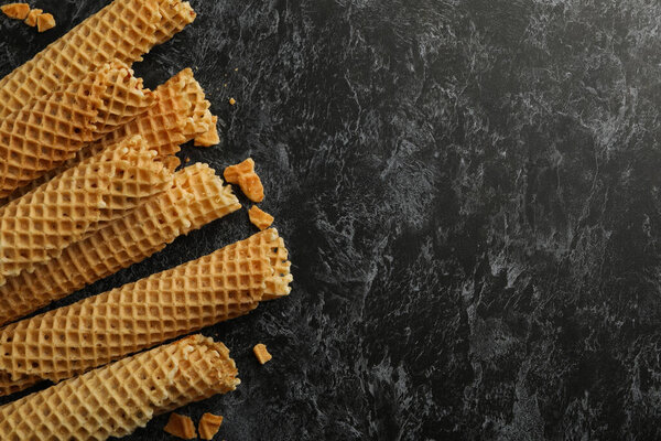 Вафельные рулоны с сгущенным молоком на черном фоне