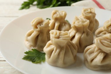 Beyaz ahşap arka planda bir tabak khinkali ile lezzetli öğle yemeği kavramı