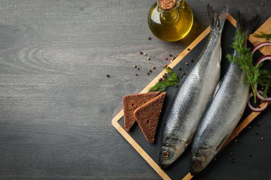 Ringa balığı, baharat ve koyu ahşap arka planda yağlı tahtalar.