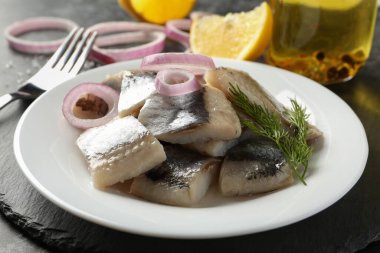 Bir tabak taze balık dilimli siyah tepsi.