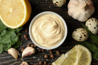 Mayonez ve ahşap arka planda yemek yapmak için malzemelerle dolu bir kase.