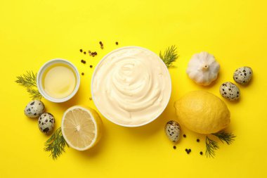 Sarı arka planda mayonez ve malzemelerle dolu bir kase.