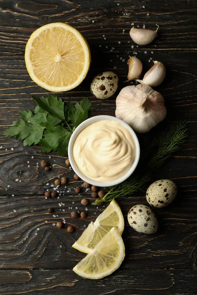Mayonez ve ahşap arka planda yemek yapmak için malzemelerle dolu bir kase.