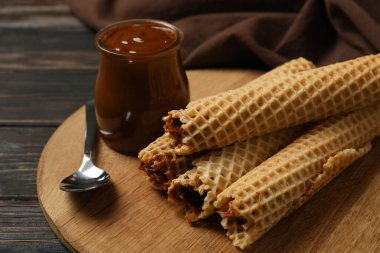 Tahta arka planda yoğunlaştırılmış sütle birlikte gofretli lezzetli yemek kavramı