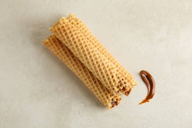 Beyaz desenli arka planda yoğunlaştırılmış sütle lezzetli gofretler.