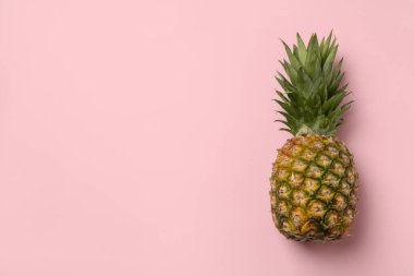 Pembe arka planda lezzetli olgun ananas, metin için boşluk