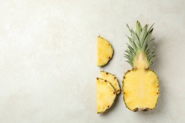 Beyaz desenli arka planda ananas ve dilimler ile düz yatıyordu