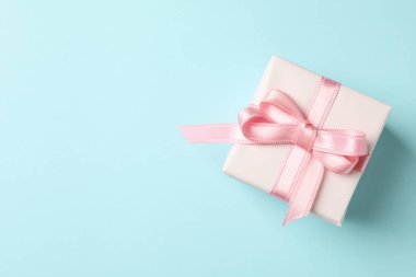 Mavi arka planda pembe kurdeleli hediye kutusu