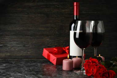 Siyah dumanlı masada güller ve şarapla Sevgililer Günü kavramı
