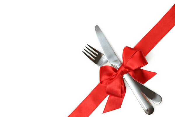 Столовые приборы с красным бантом изолированы на белом фоне