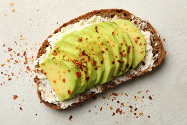 Beyaz arka planda avokadolu lezzetli bir tost.