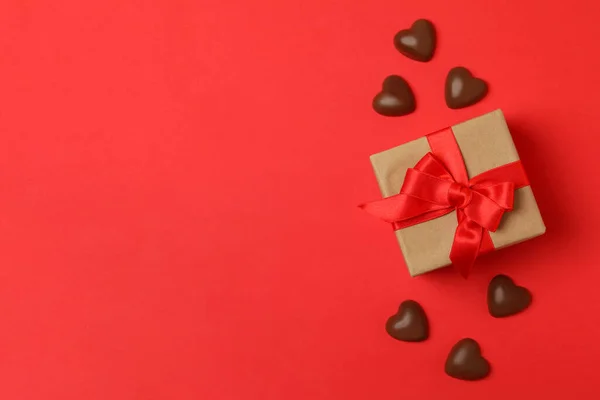 Geschenkbox Und Schokoladenherzen Auf Rotem Hintergrund — Stockfoto