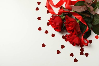 Güller, dekoratif kalpler ve beyaz arka planda kurdele.