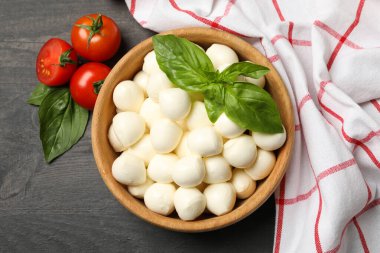 İçinde mozzarella ve fesleğen, domates ve havlu olan koyu ahşap arka plan, üst manzara.