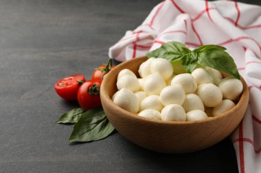 İçinde mozzarella ve fesleğen, domates ve havlu olan koyu dokulu arka plan, metin için alan