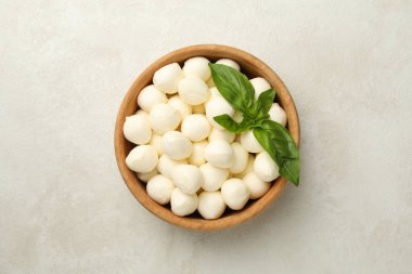 Beyaz desenli arka planda mozzarella ve fesleğenli kase.