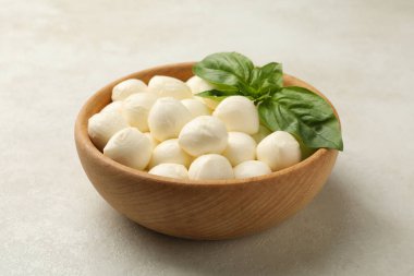 Beyaz desenli arka planda mozzarella ve fesleğenli kase.