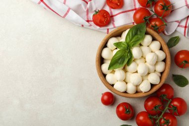 Beyaz desenli arka planda mozzarella ve fesleğen, domates ve havlu ile kase, metin için boşluk