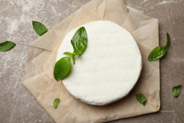 Gri arka planda peynirli ve fesleğenli fırın kağıdı.