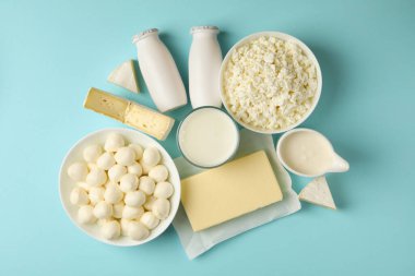 Mavi arka planda farklı taze süt ürünleri, üst görünüm