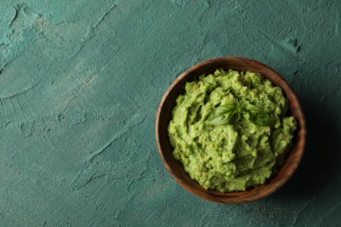 Yeşil desenli arka planda bir kase guacamole, metin için boşluk