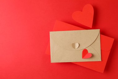 Kırmızı arkaplanda zarflar ve kalpler, metin için boşluk