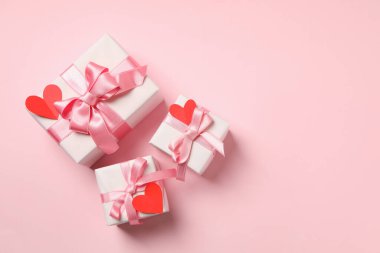 Pembe arka planda dekoratif kalpleri olan hediye kutuları.