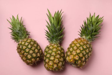 Pembe arka planda üç lezzetli olgun ananas.