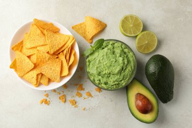 Beyaz desenli arka planda guacamole ve cips ile lezzetli yemek kavramı, üst görünüm