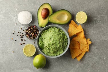Gri arka planda guacamole ve malzemelerle lezzetli yemek kavramı