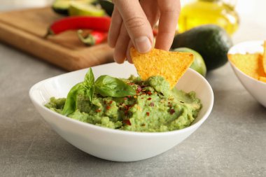 Kadın el daldırıyor cipsleri dilimliyor guacamole, kapatıyoruz