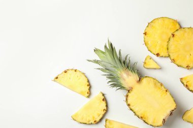 Beyaz zemin üzerinde ananas ve dilimler ile düz yatıyordu