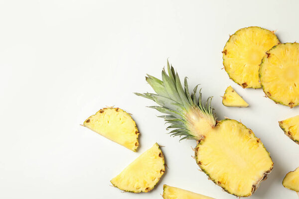 Flat lay with pineapple and slices on white background