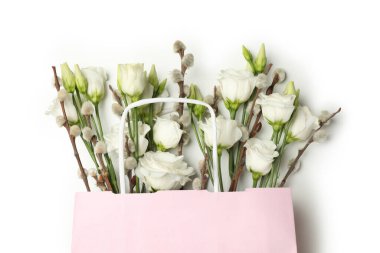 Beyaz arka planda gül ve söğüt çiçekli pembe kağıt çanta.