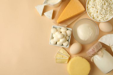 Bej arka planda farklı taze süt ürünleri, üst görünüm