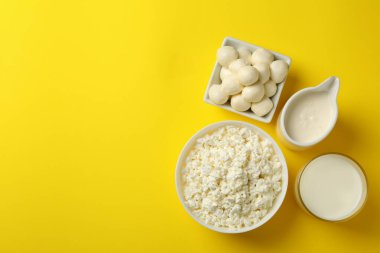 Sarı arka planda farklı taze süt ürünleri, üst görünüm