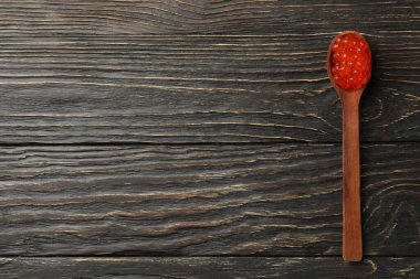 Ahşap zemin üzerinde kırmızı havyar ile kaşık, metin için boşluk