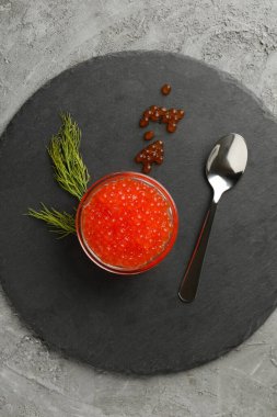 Kırmızı havyar, kaşık ve dereotlu tepsi gri arka plan, üst görünüm